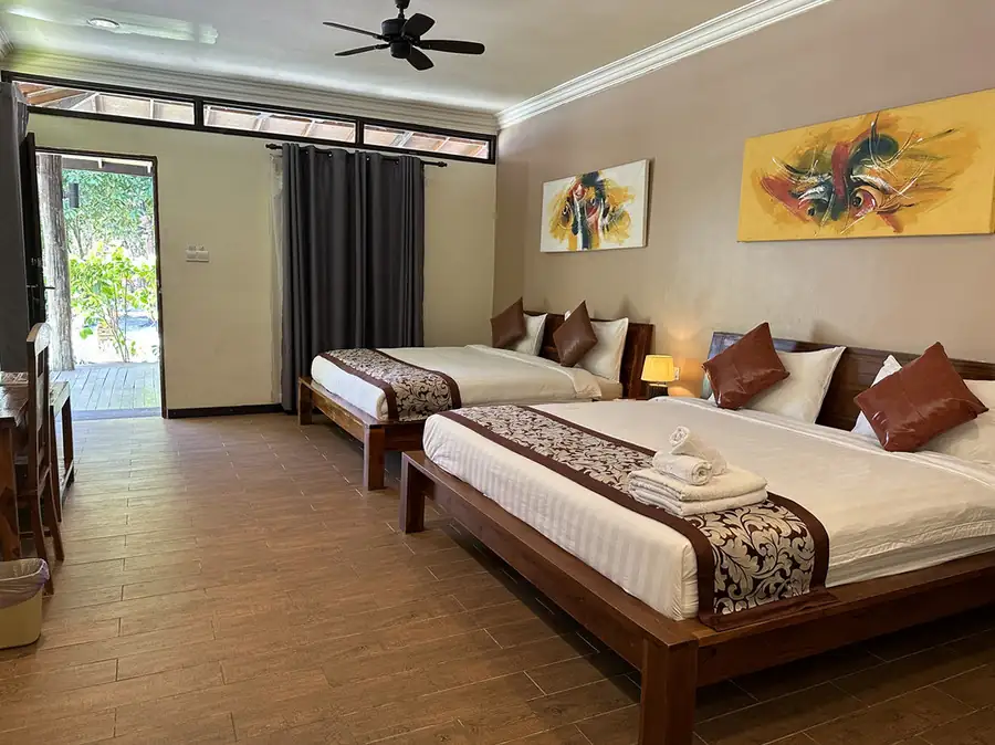 A comfortable bedroom presenting two beds with patterned bedding at Mussah Poteh Resort