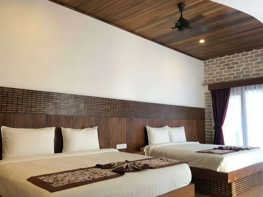 A lovely bedroom equipped with two beds and textured wall art at Mussah Poteh Resort